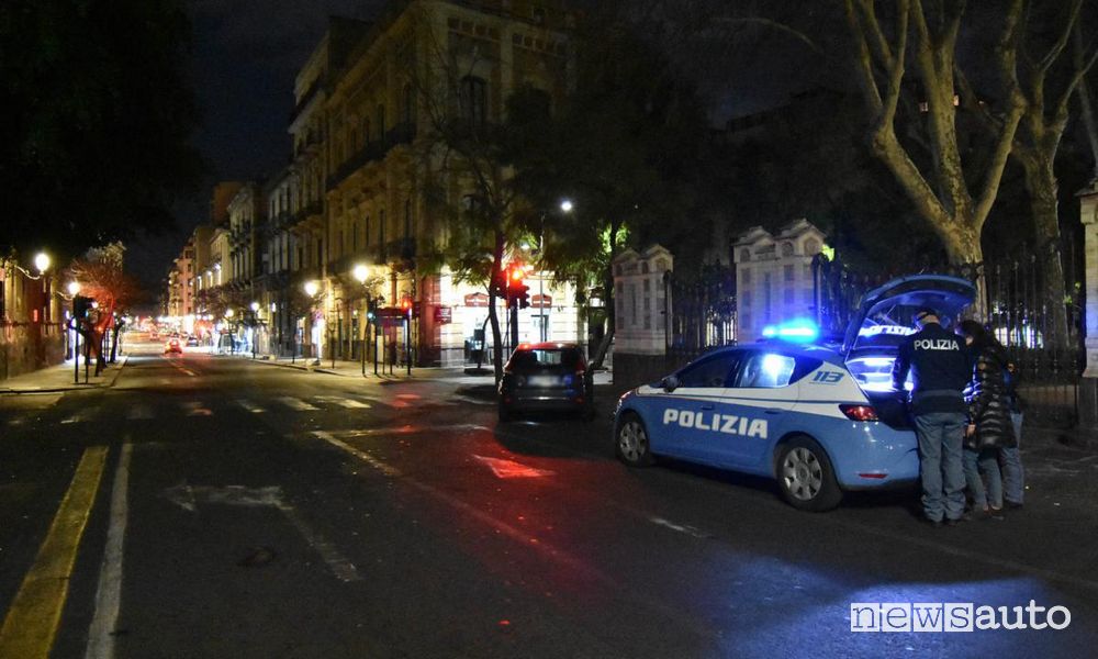Durante il coprifuoco le Forze dell'Ordine controllano: l'ordine è di restare a casa durante l'ore notturne (auto della polizia con lampeggianti accesi)