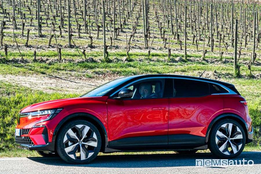 Vista laterale nuova Renault Mégane E-TECH Electric rossa su strada