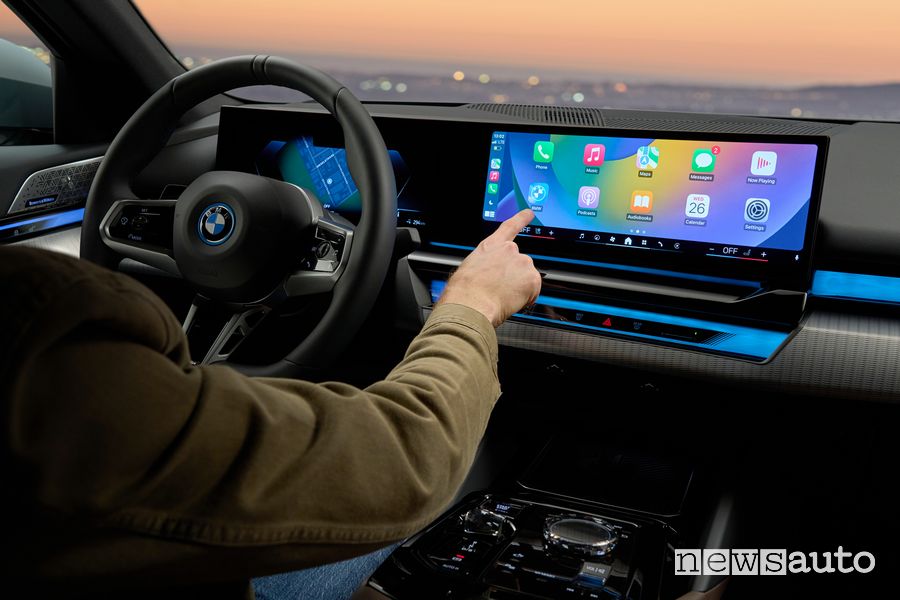 Le auto moderne smart car connesse come la BMW i5 eDrive40 elettrica, sul display l'infotainment con Apple CarPlay