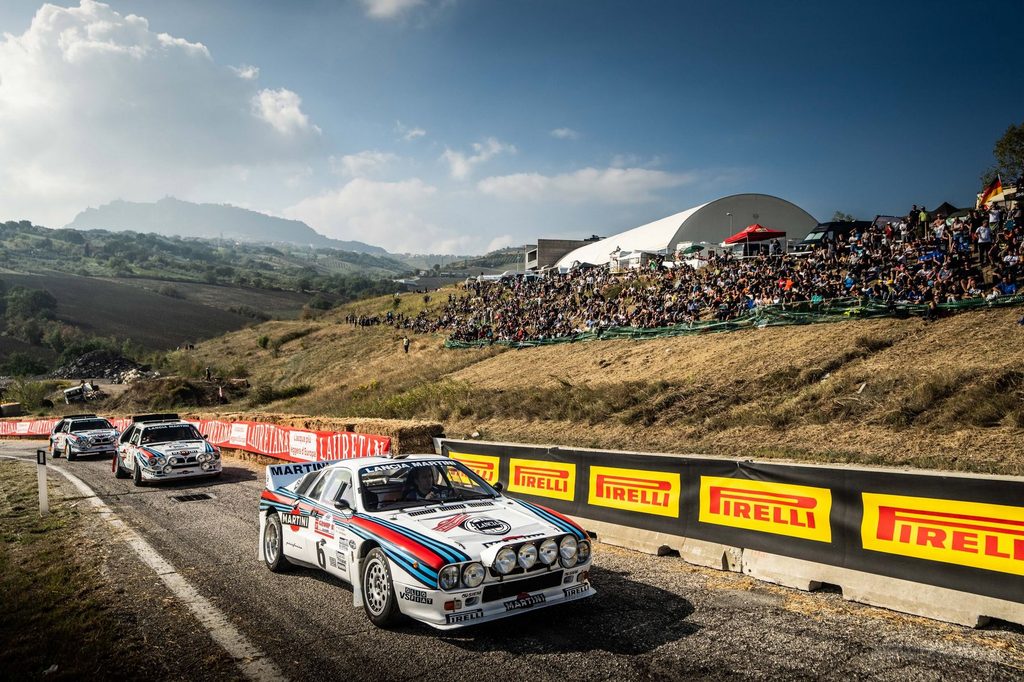 Alessandro Bettega sulla Lancia 037 Martini Racing al Rallylegend 2026, accompagnato da Markku Alén, Miki Biasion e due Lancia Delta S4.
